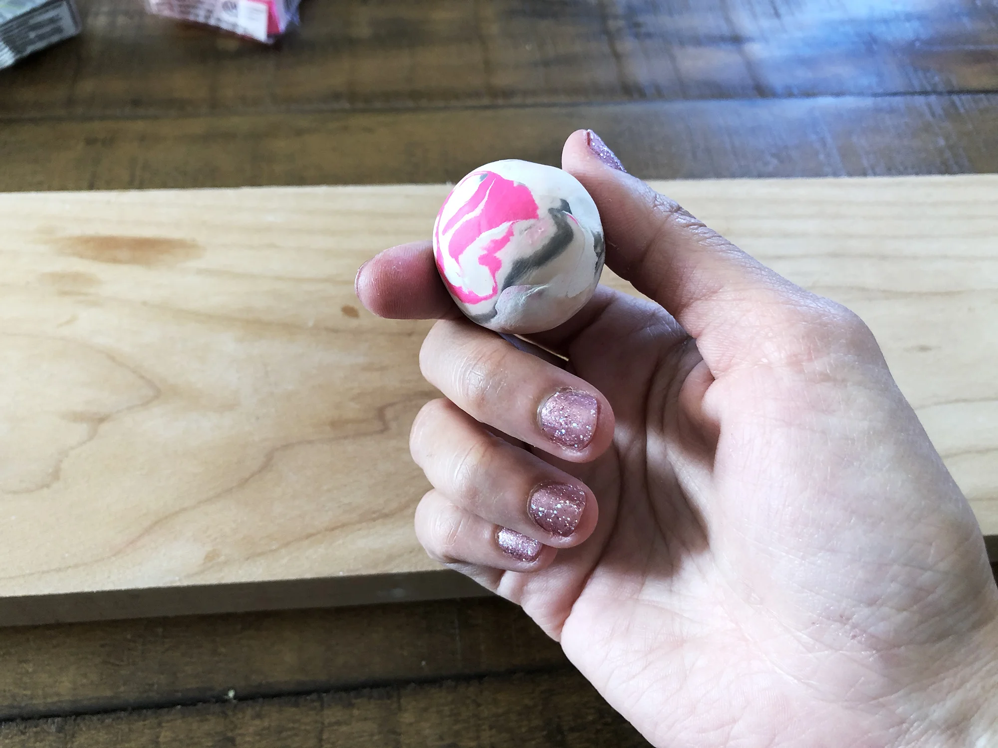 5. Roll it up into a ball. Depending on how blended you want you 'marble' to look, you can squish them as much as you like to get the marble pattern you're happy with!