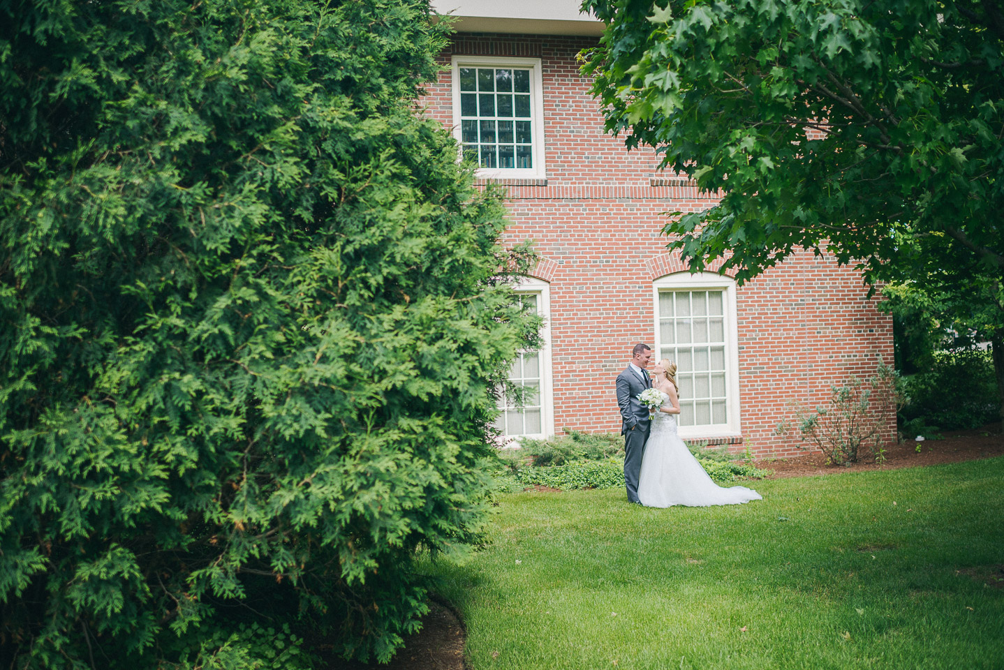 NH Wedding Photographer: couple in garden against old brick