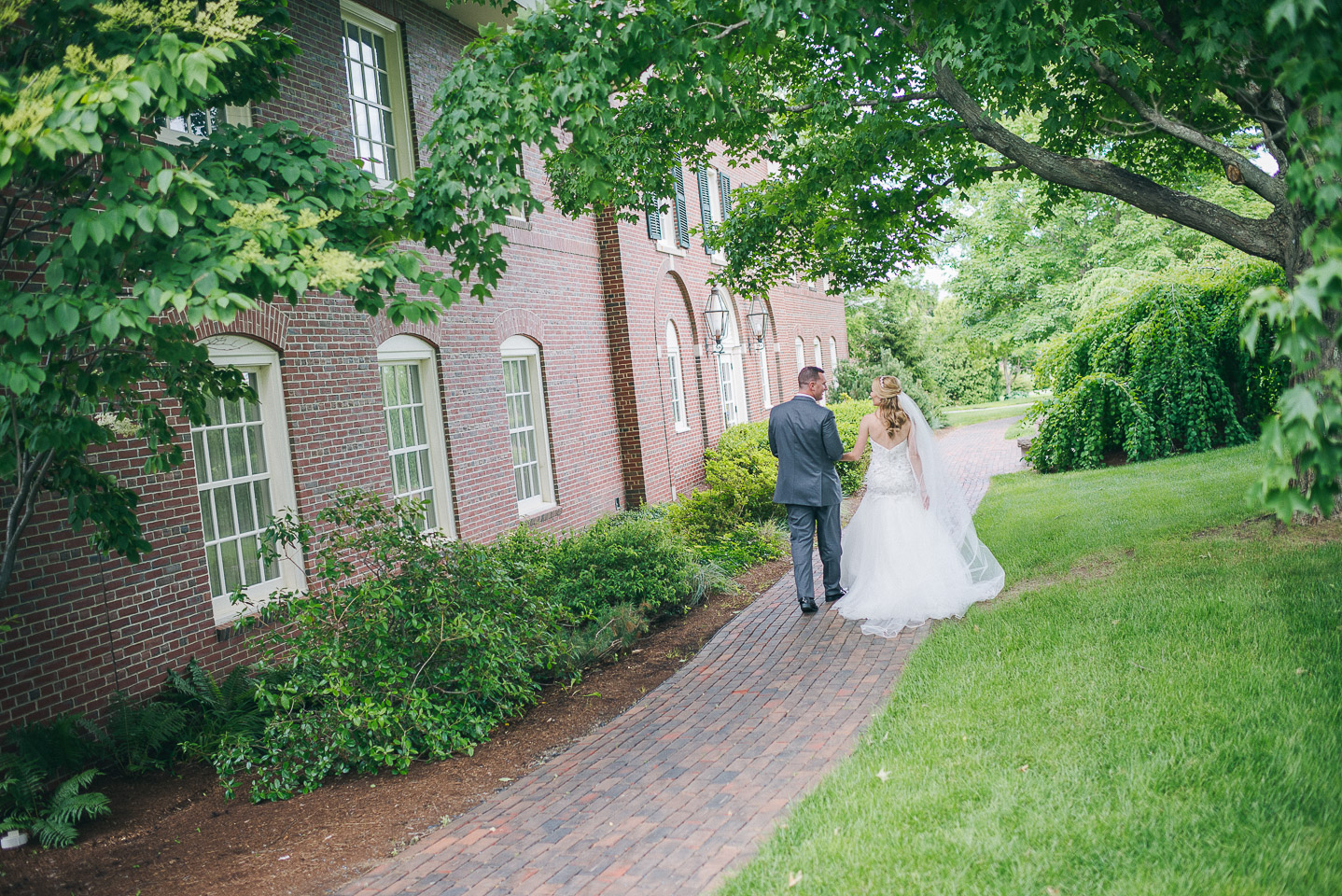 NH Wedding Photographer: newlyweds walking at Saint Anselm