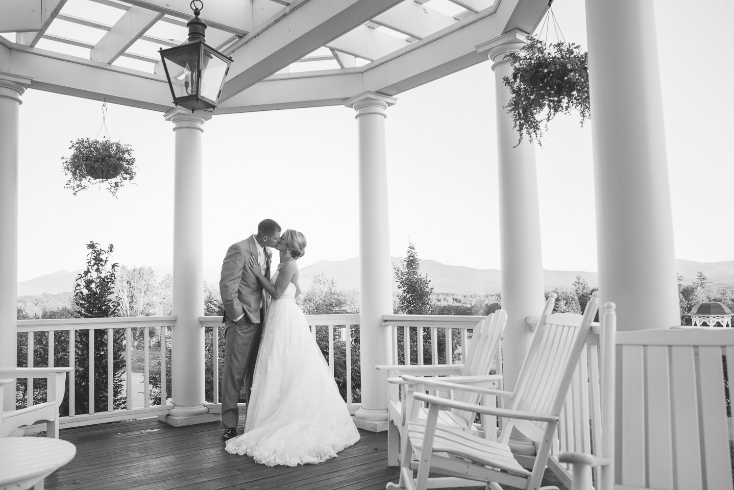 NH Wedding Photographer: bride and groom kissing on front porch