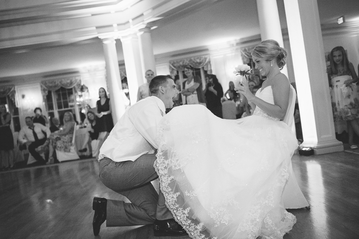 NH Wedding Photographer: groom takes garter from bride