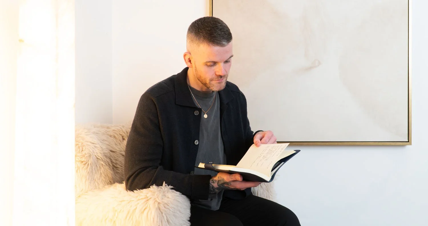 A portrait of Kyle Gray reading his journal