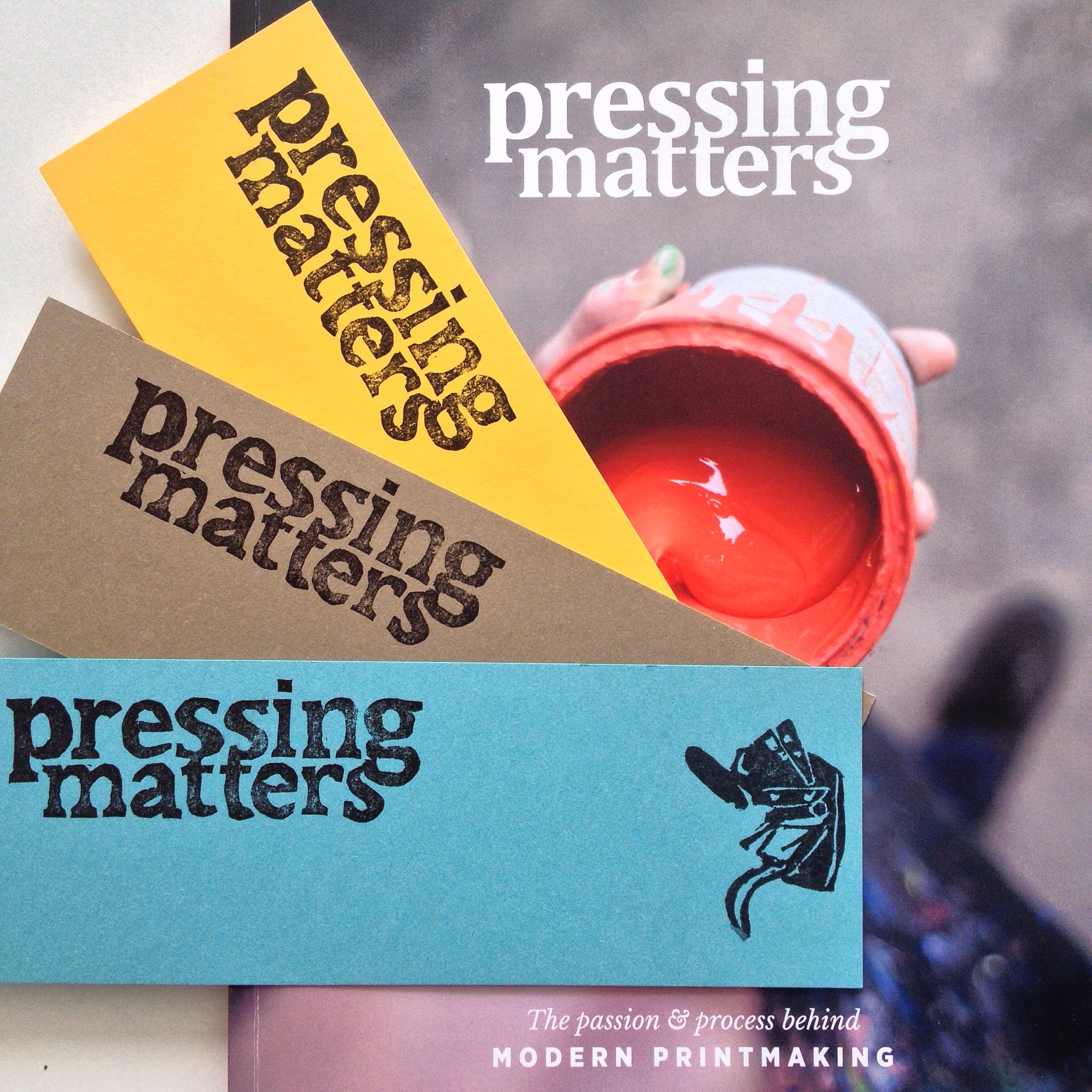 Printing Pressing Matters bookmarks with a hand carved rubberstamp print of the adana 8 x 5 printing press. John Coe’s first issue of Pressing Matters Magazine.&nbsp;