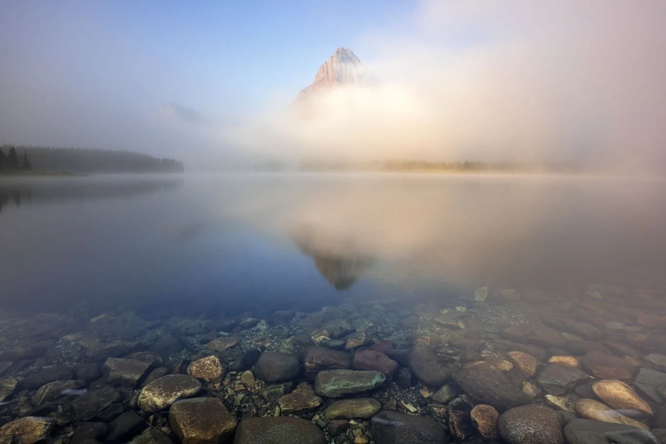 The morning greeted me with a heavy fog my first morning in Glacier this past September. Patience paid off though as the fog gradually revealed the mountains from the shores of Swiftcurrent Lake 💙 @glacier_national_park 
.
A group of photographers f