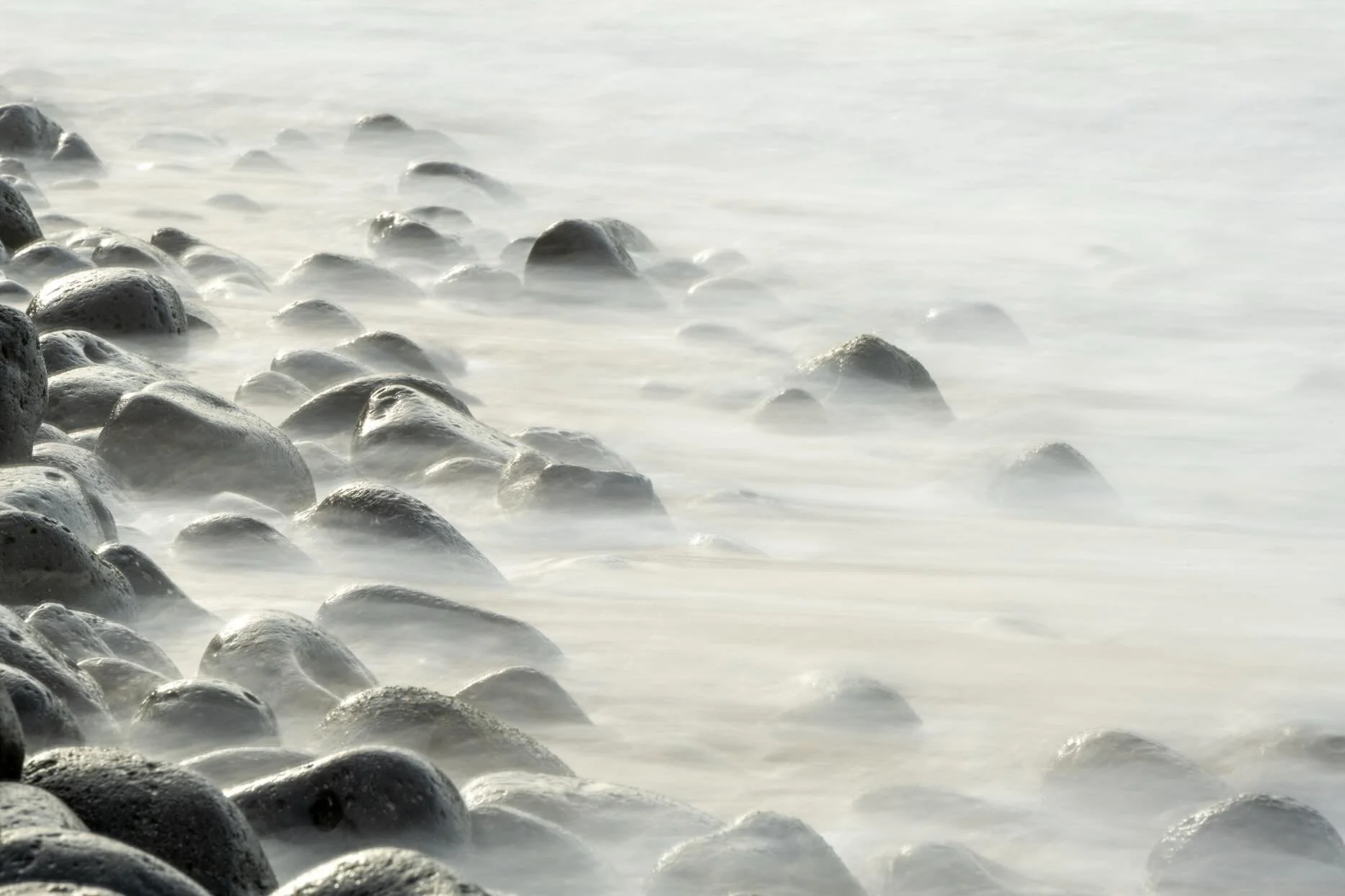 Watching the waves flow back over the rocks, rattling as they went was mesmerizing and it was meditative to play with perspective and shutter speeds to capture some small scenes of the movement as the sunlight came in and out through the clouds. Whic