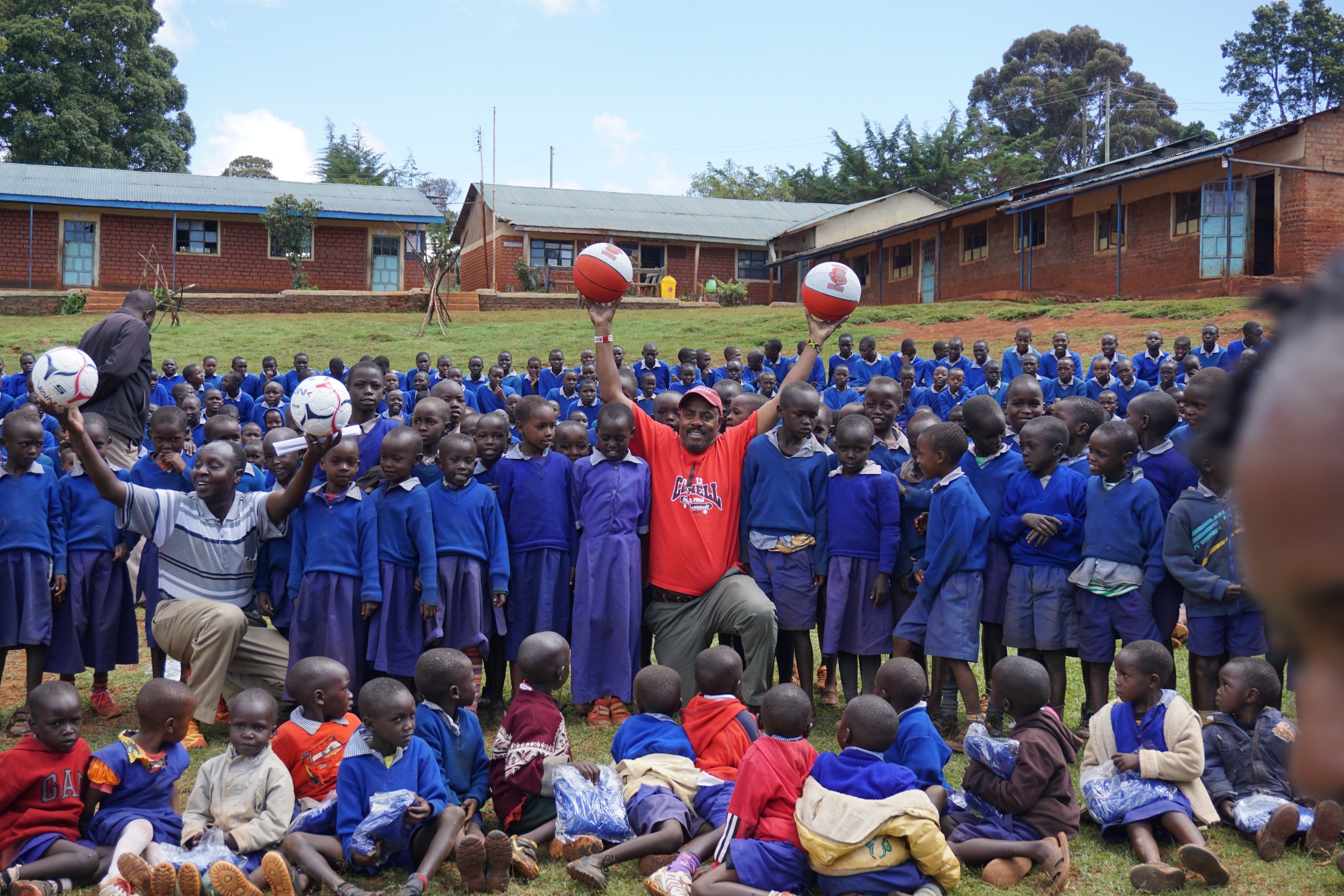 CWA director Kevin Thompson distributing soccer and basketball's with Kamariny School Principal Robert Kiptoo