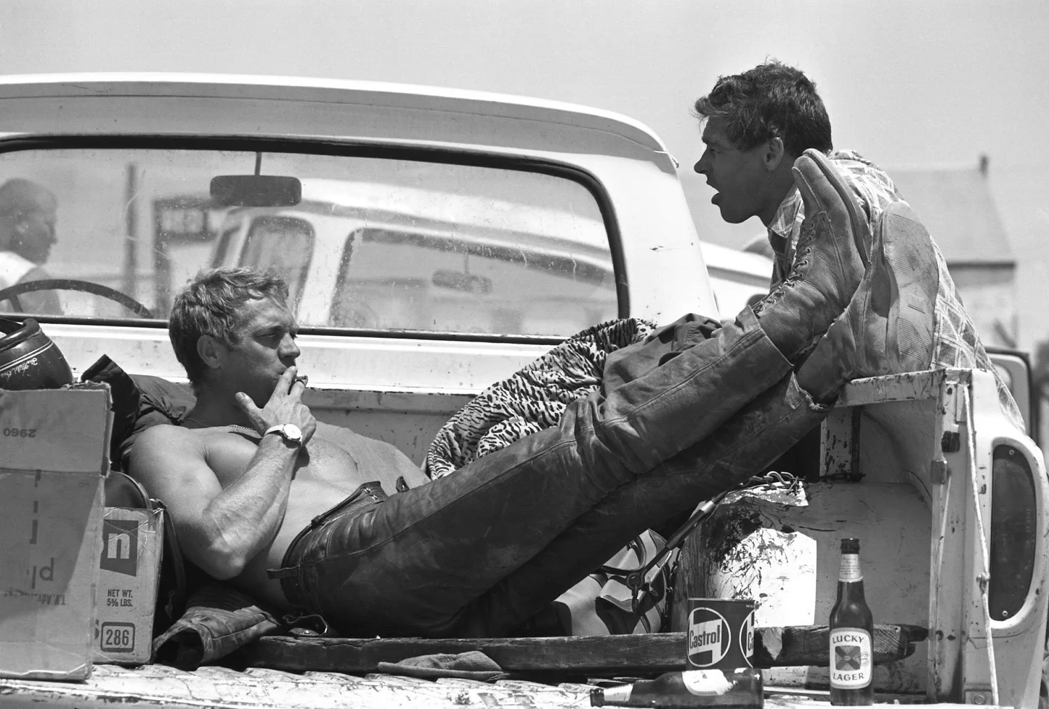Steve McQueen relaxing in a pickup truck with a few Lucky Lagers