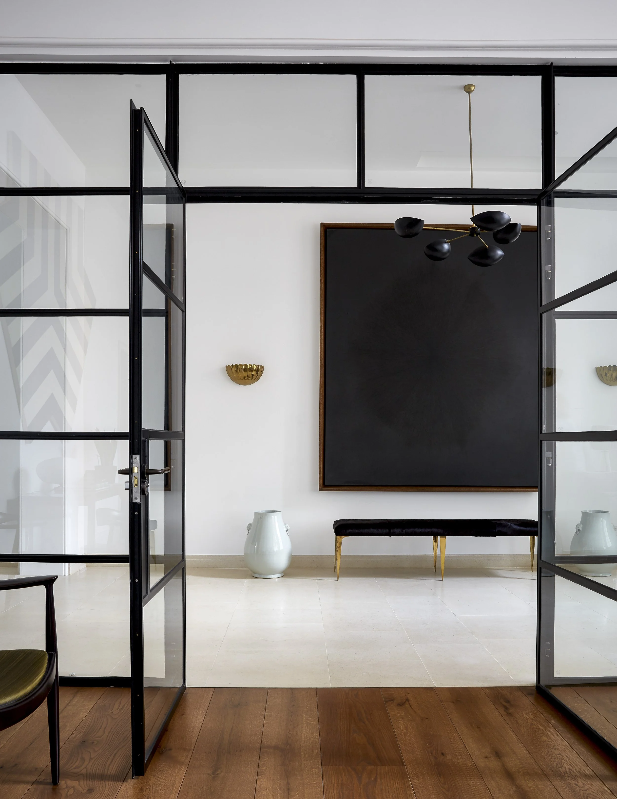 Contemporary hallway with Crittall glass partition bringing light into Chelsea townhouse