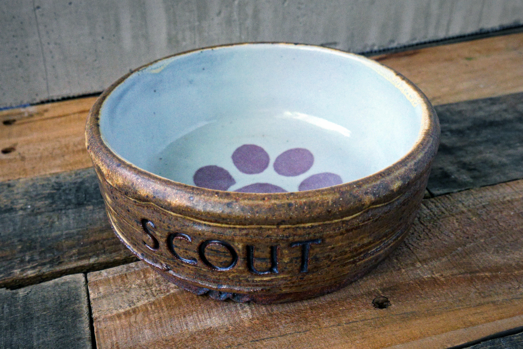 Medium pet dish in yellow salt with with custom text andred paw print on white.