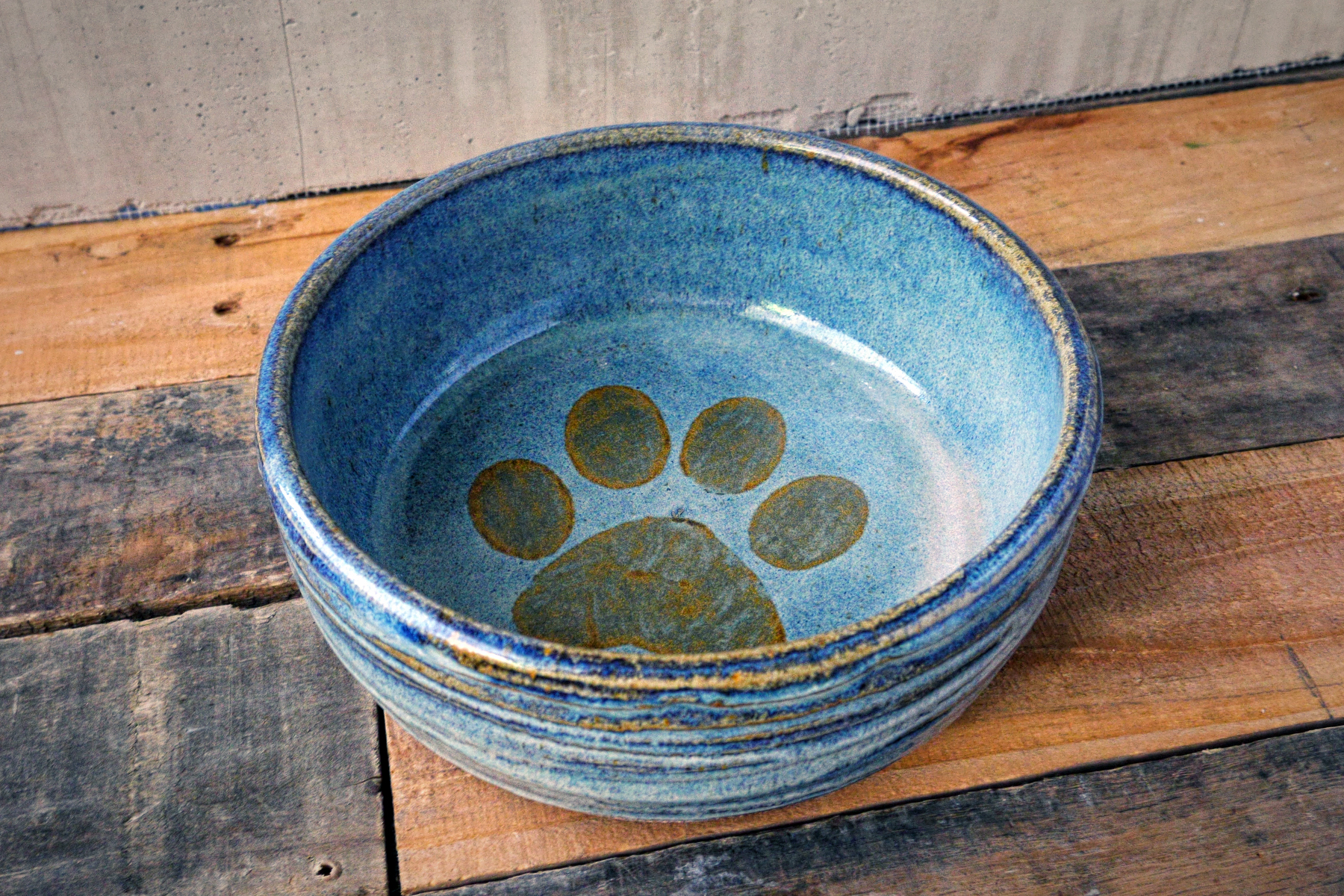 Large pet dish in rusted blue with iron paw print on rusted blue.