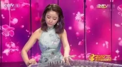 林心如在春节联欢晚会的舞台上 ，她弹奏着古筝。