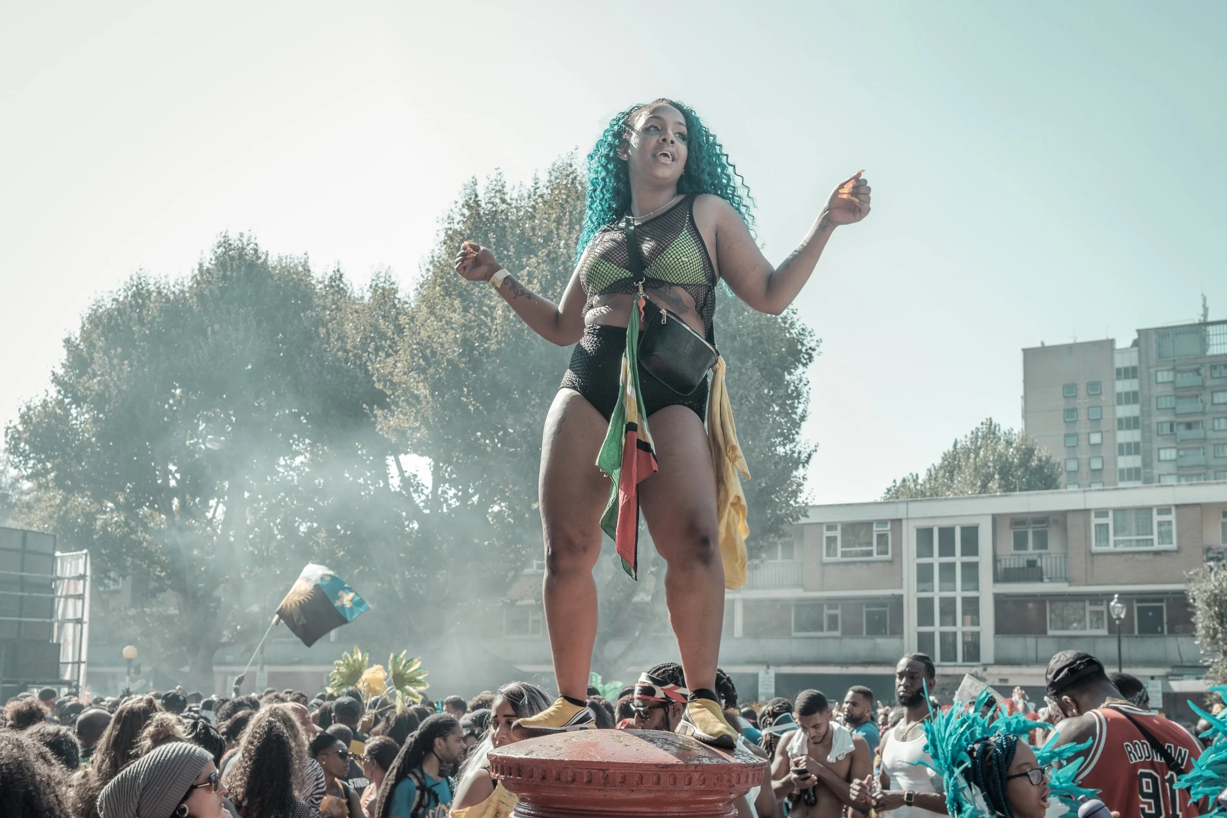 A Carnival masquerader stands above the crowd at Notting Hill Carnival in London, photographed for Carnival of Resistance, an ongoing documentary exploring culture, identity and community.