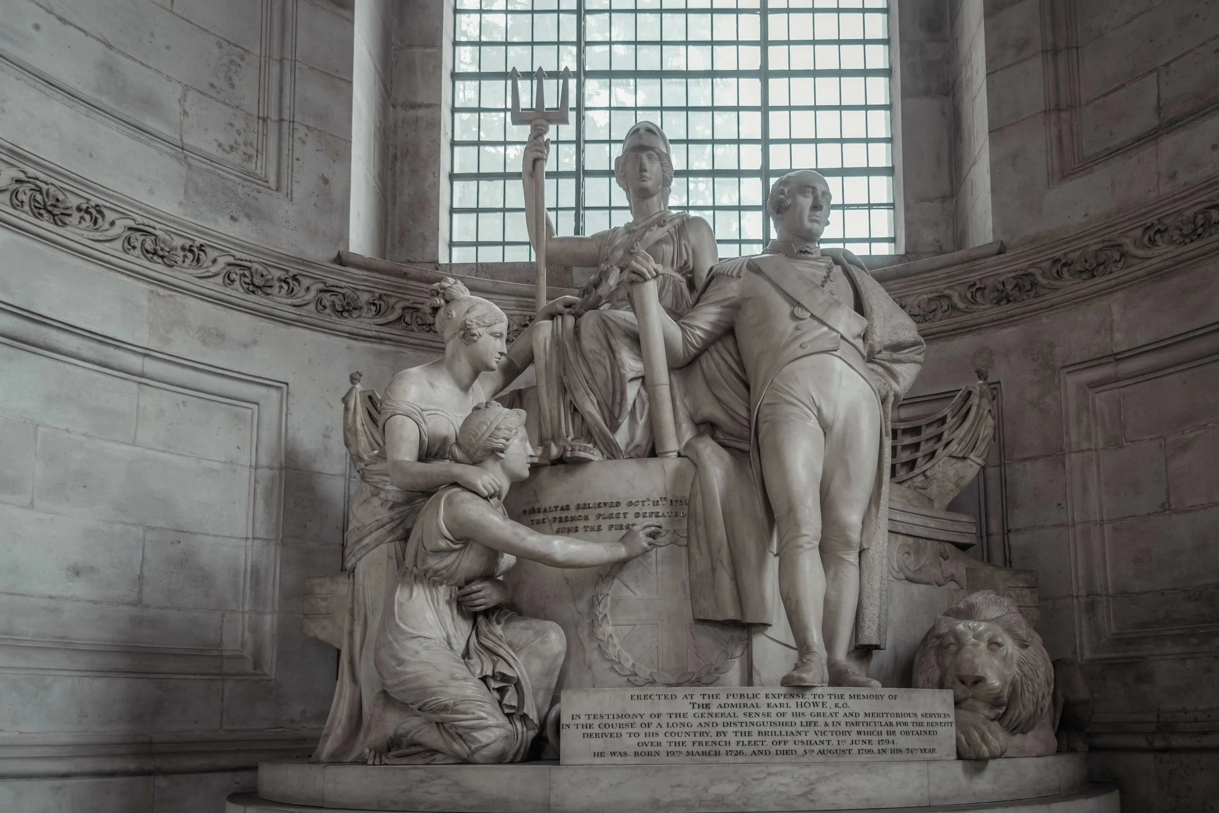 Large marble memorial sculpture inside St Paul's Cathedral, illuminated by natural light from a tall window.