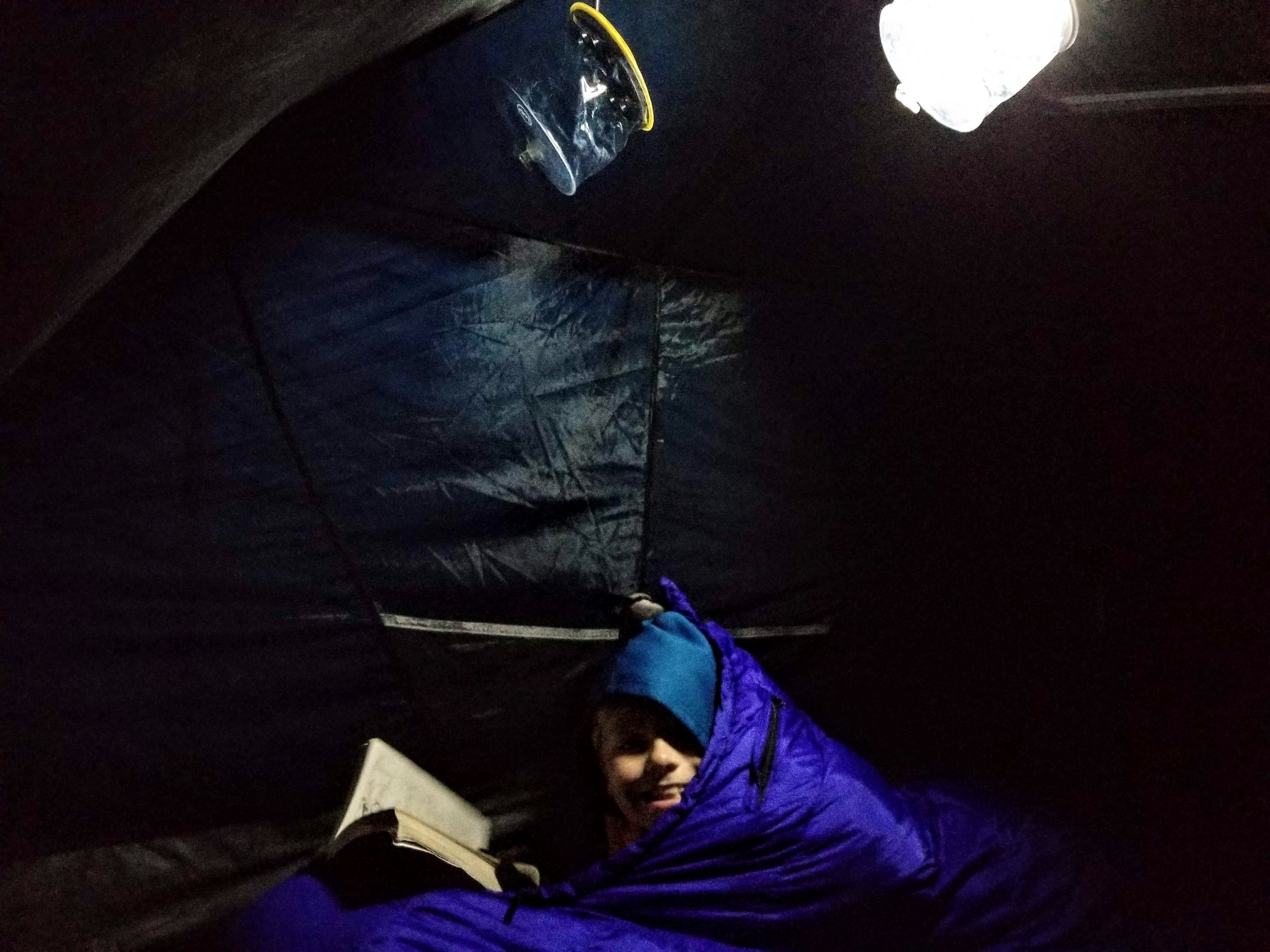 Reading by the light of a Luci light in the tent. 