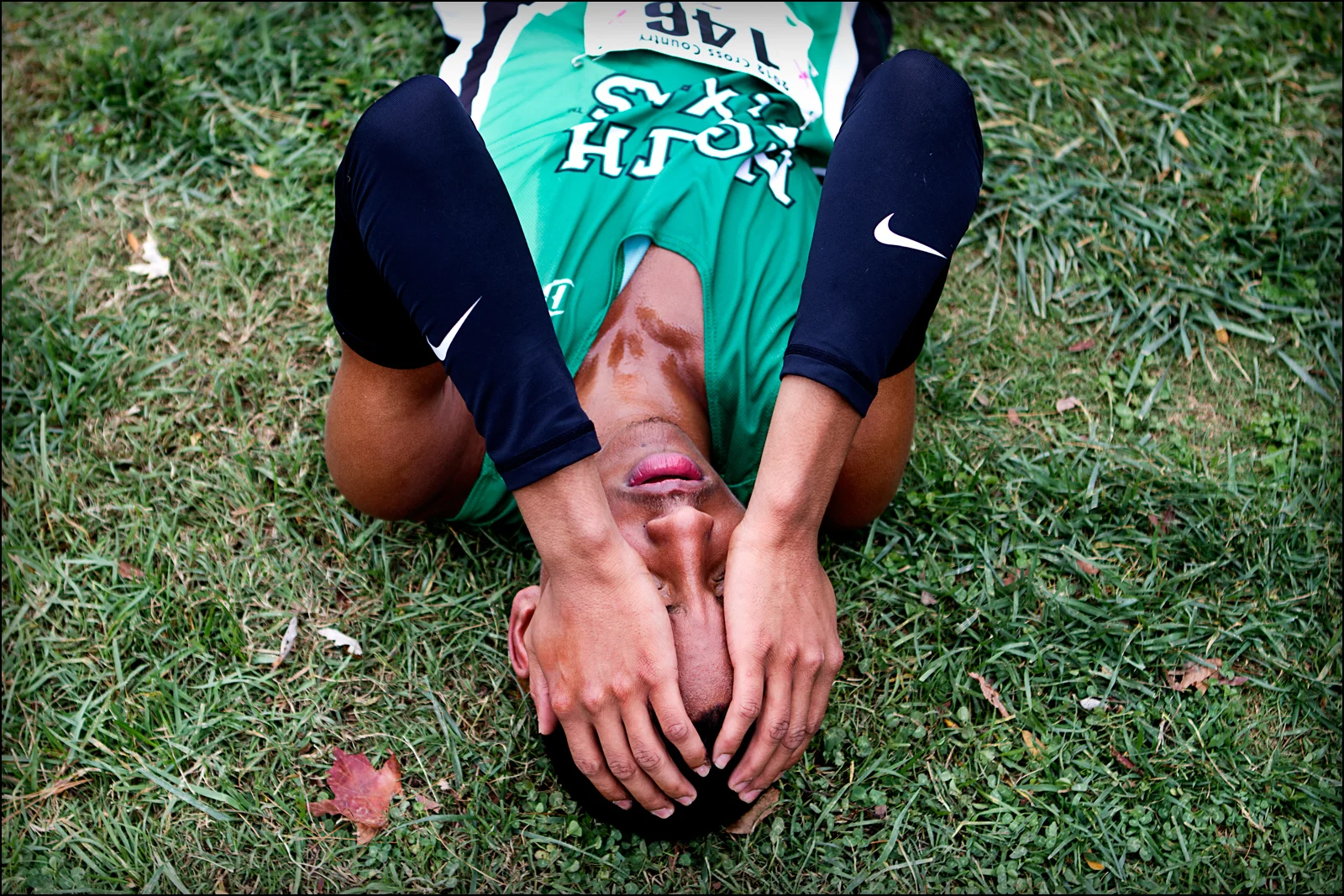 University of North Texas Silvester Harrison collapses onto the ground after finishing the mens 8K run at the Sun Belt Cross Country Championships held at Kereiakes Park in Bowling Green, KY. Harrison finished 21st to help his team finish first place in the competiton.