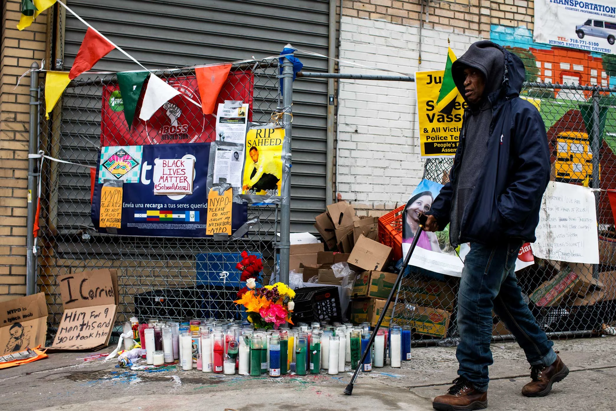 A man walk past the memorial site for Saheed Vassell in Crown Heights Brooklyn.