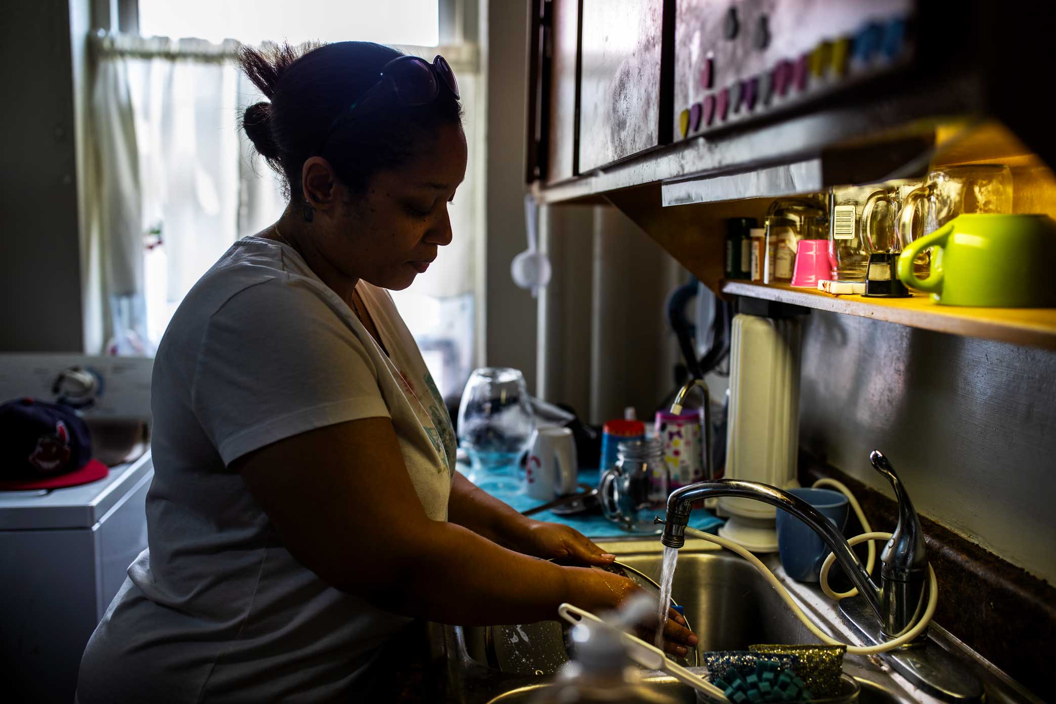Shaly Ramirez washes dishes in her apartment.