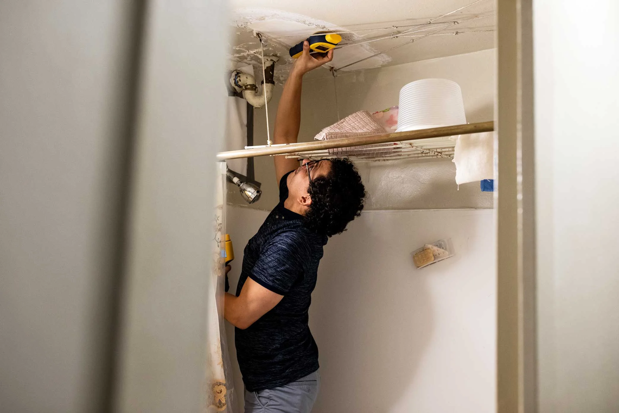 Ray Lopez, director of environmental health for LSA Family Health Service, uses a device that reads moisture levels during a home visit at Manhattan’s Taft Houses.