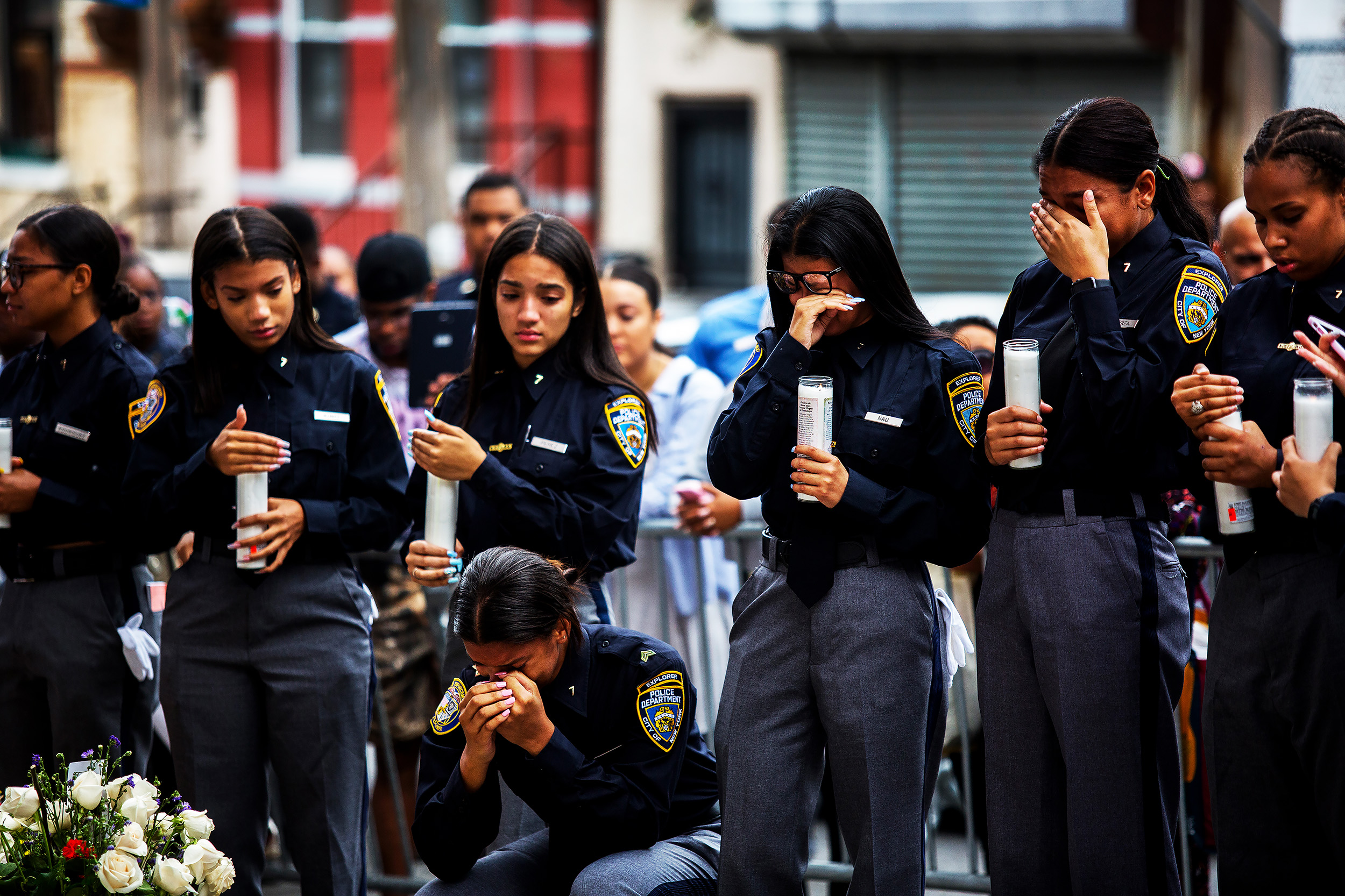 Members of the Law Enforcement Explorers program, a New York Police Department program for high school students, light candles at the makeshift memorial space for Lesandro Guzman-Feliz in the Bronx on June 27, 2018. Hundreds attended the funeral of the 15-year-old, known as Junior, whose fatal stabbing was caught on video and stunned the city.