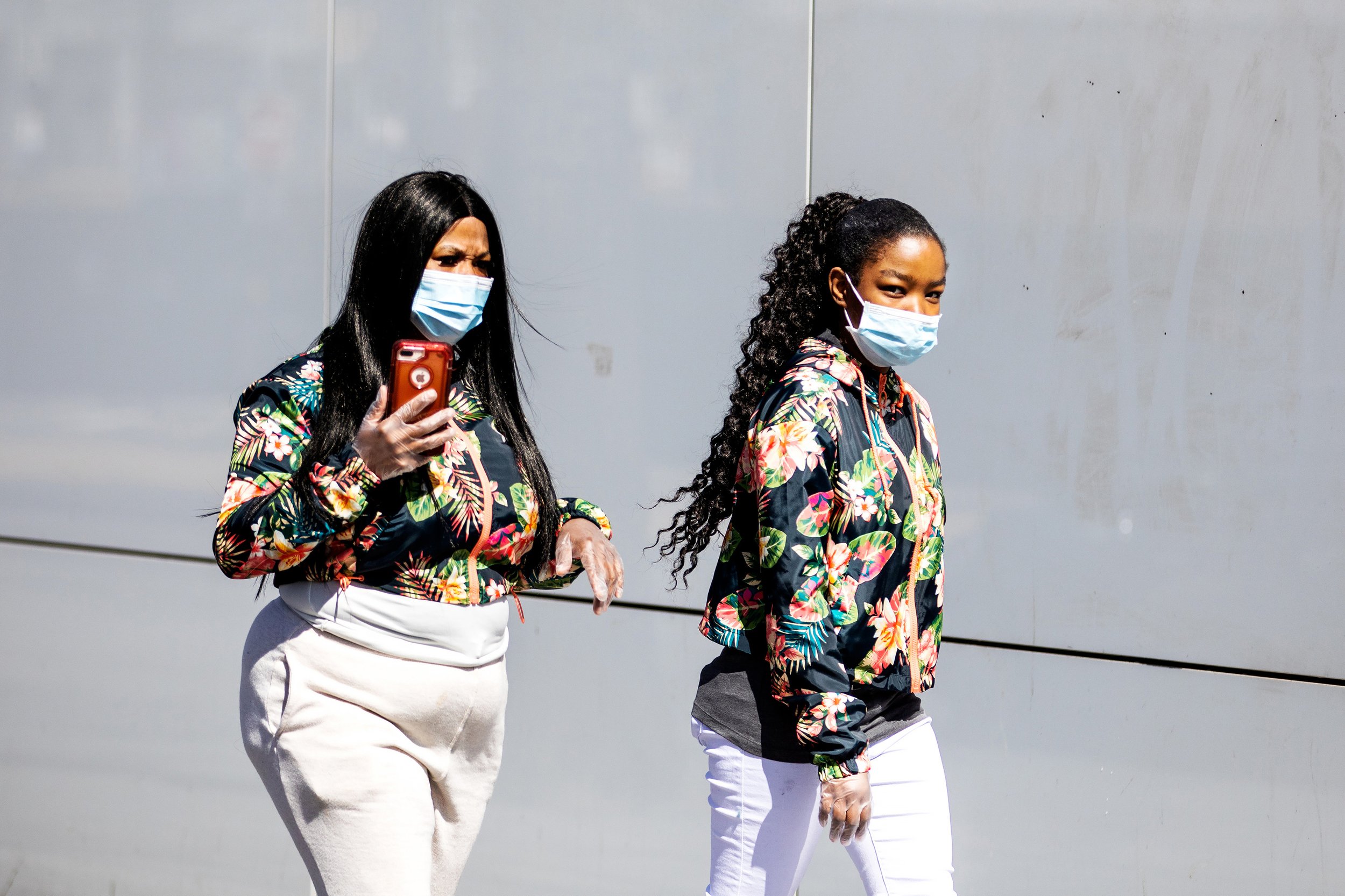  Two women wearing protective mask and gloves walk the streets in the midst of the coronavirus (COVID-19) outbreak on March 24, 2020 in Brooklyn, New york.   