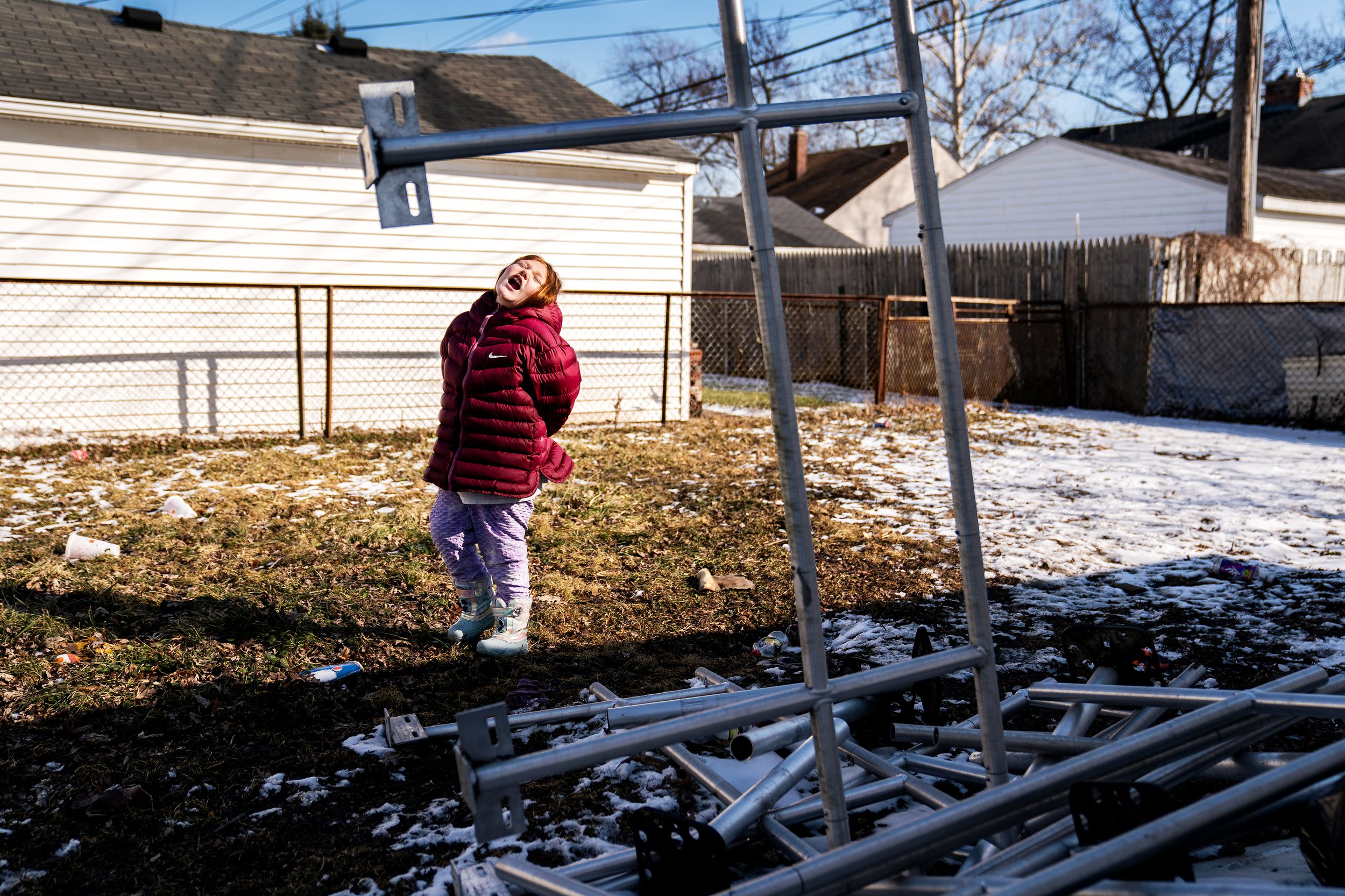  Mariah Ramsey, 7 plays with her imaginary friend next to her grandfathers handrails in the backyard of her home in Lincoln Park, Michigan. “We used to have a ramp for my father in the front of the house before he died. I’m hoping to sell it to get s