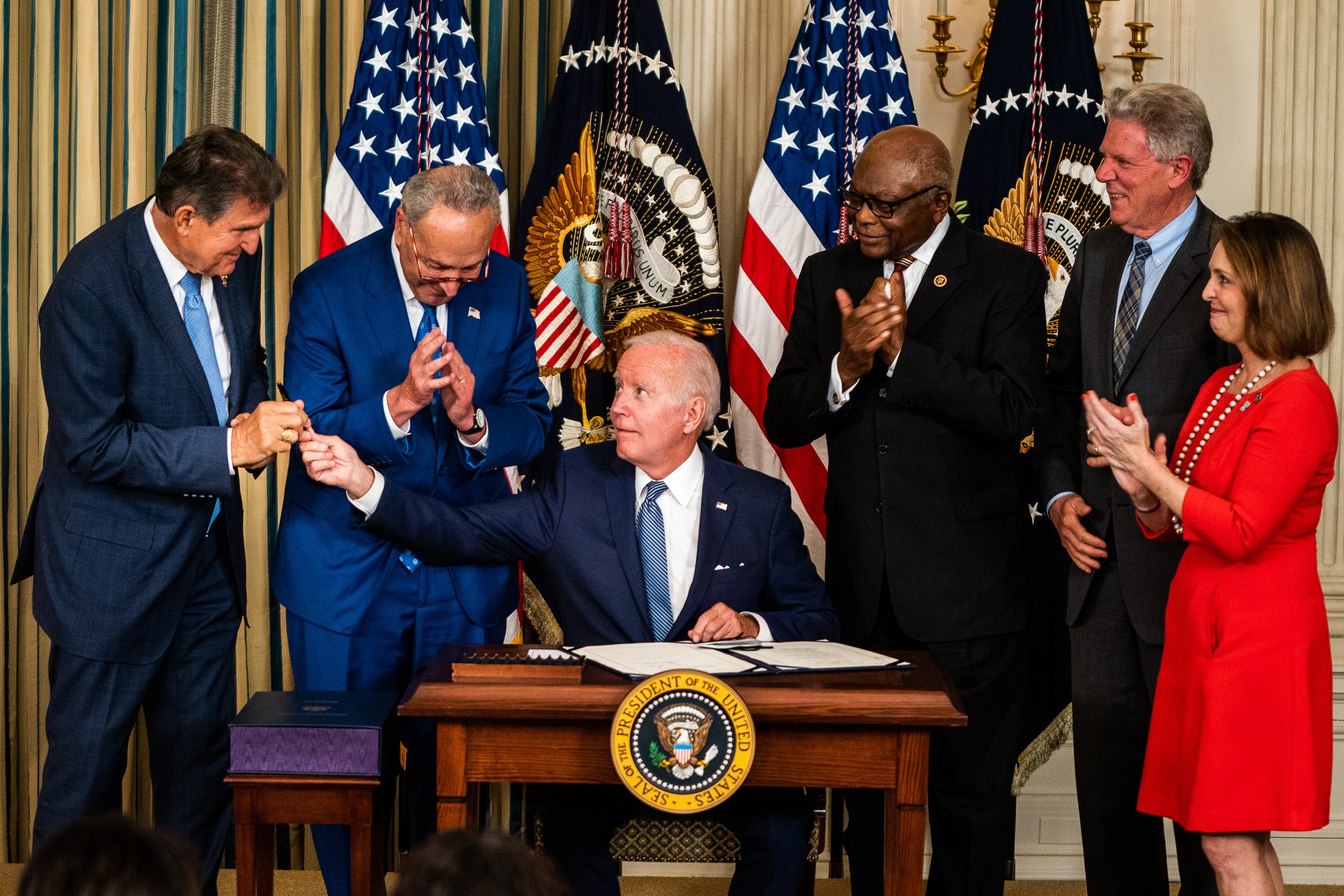  US President Joe Biden hands Sen. Joe Manchin (D-W.VA) the pen used to sign into law H.R. 5376, the Inflation Reduction Act of 2022 (climate change and health care bill) in the State Dining Room of the White House. 