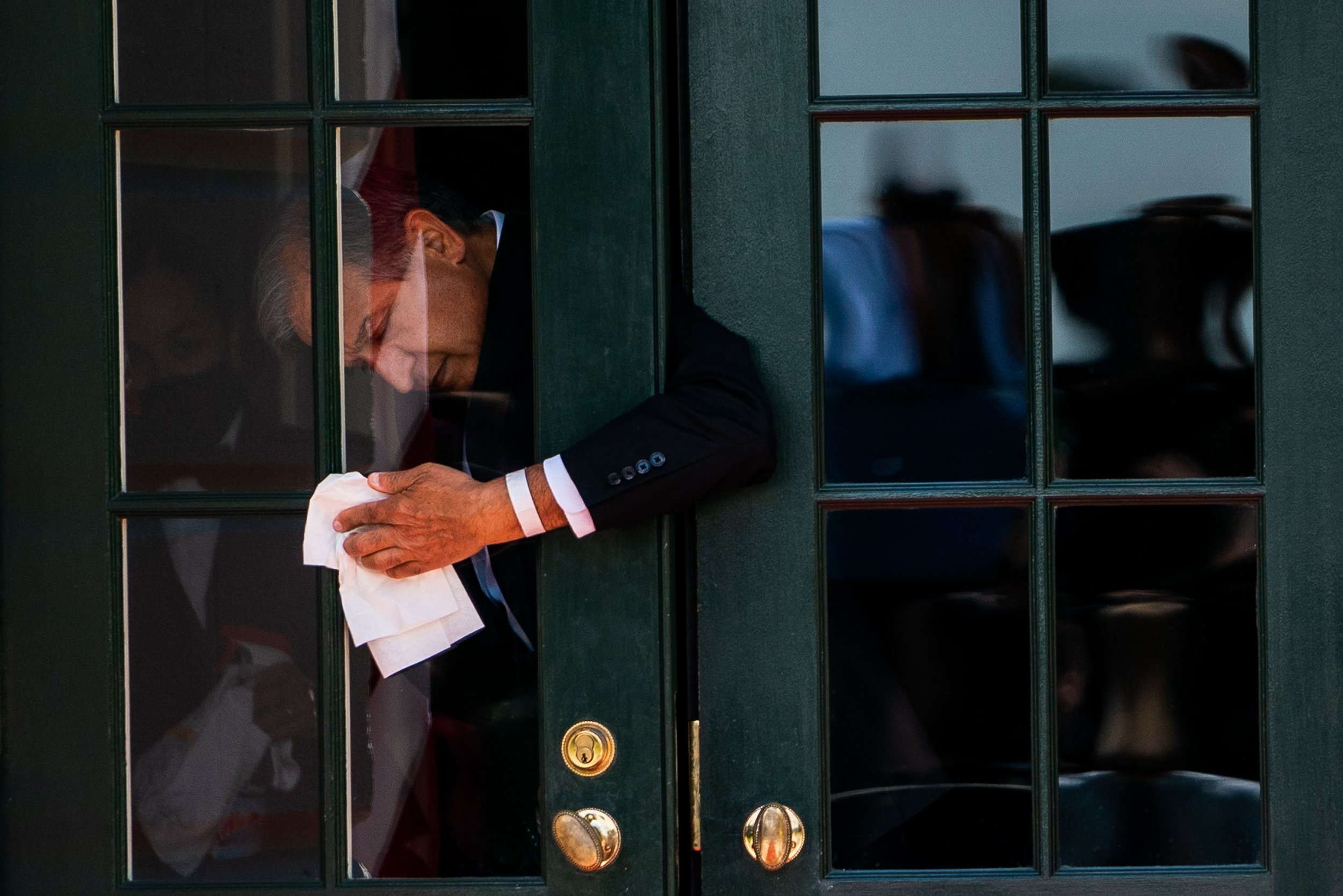  White House staffer wipes down the door before the arrival of the First Lady of Ukraine Olena Zelenska at the White House. 