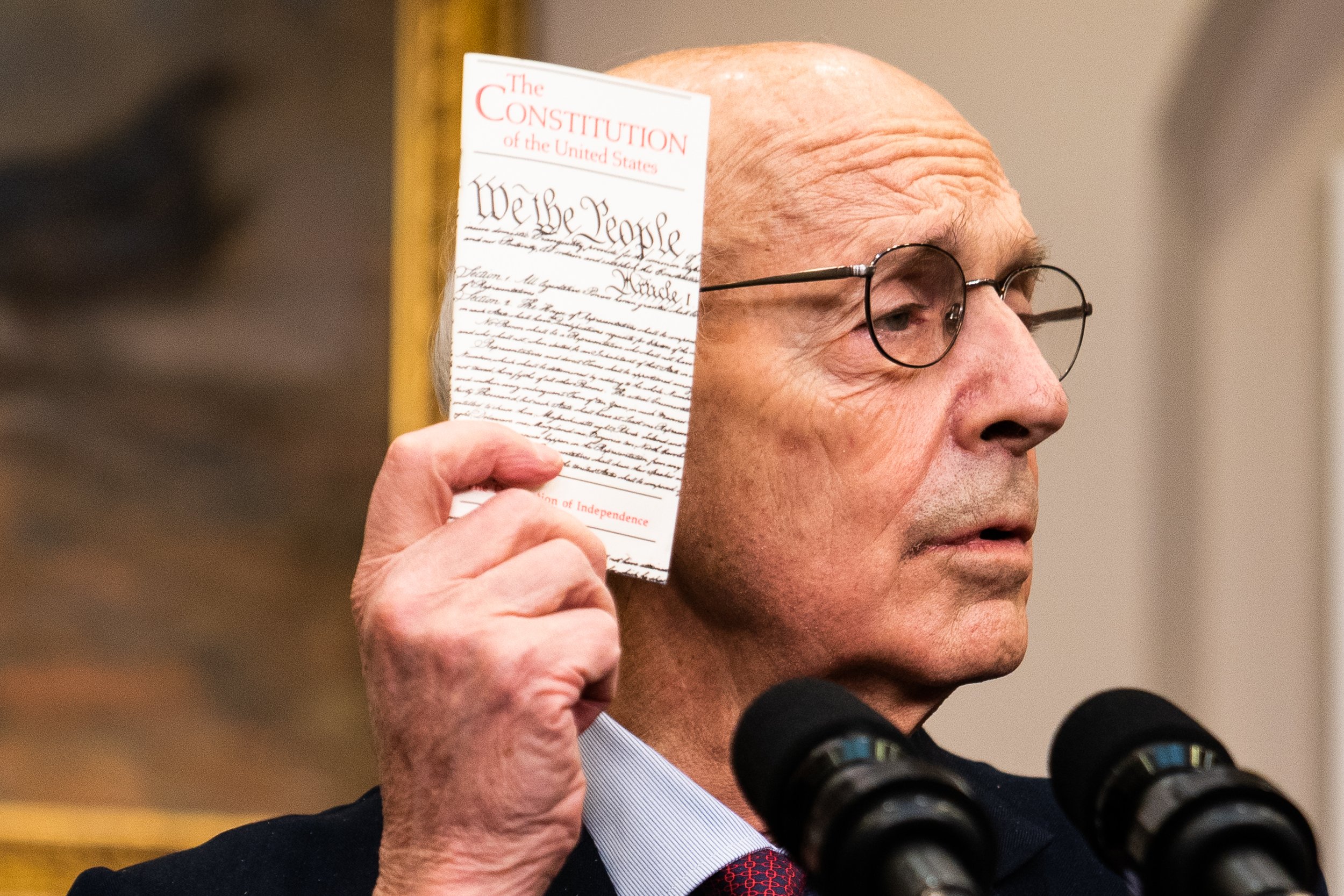  Supreme Court Justice Stephen Breyer holds up a copy of the Constitution during the announcement of his retirement with US President Joe Biden in the Roosevelt Room at the White House. 