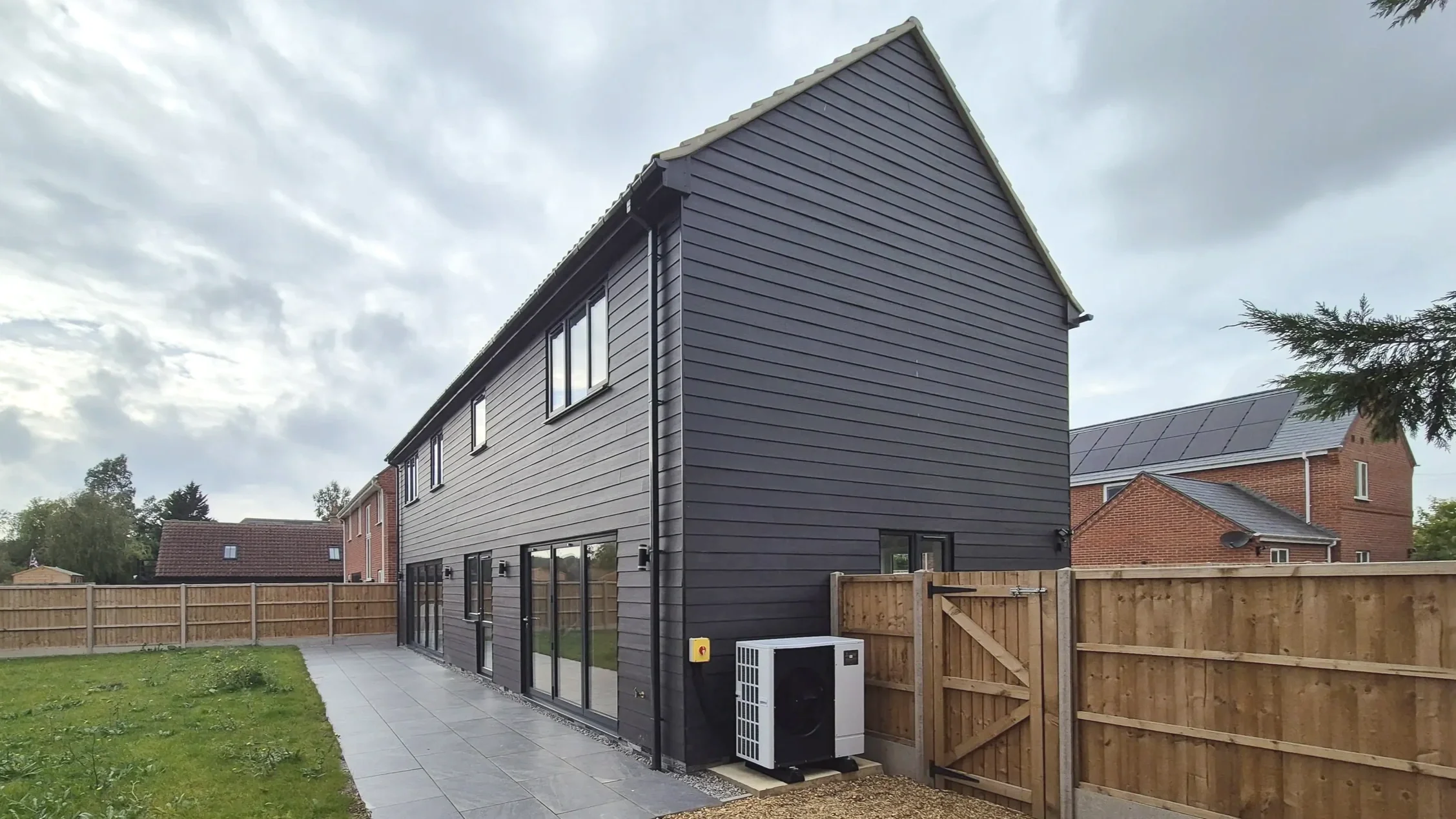 Mitsubishi Ecodan air source heat pump installed at a new-build property with the outdoor unit positioned beside the property.