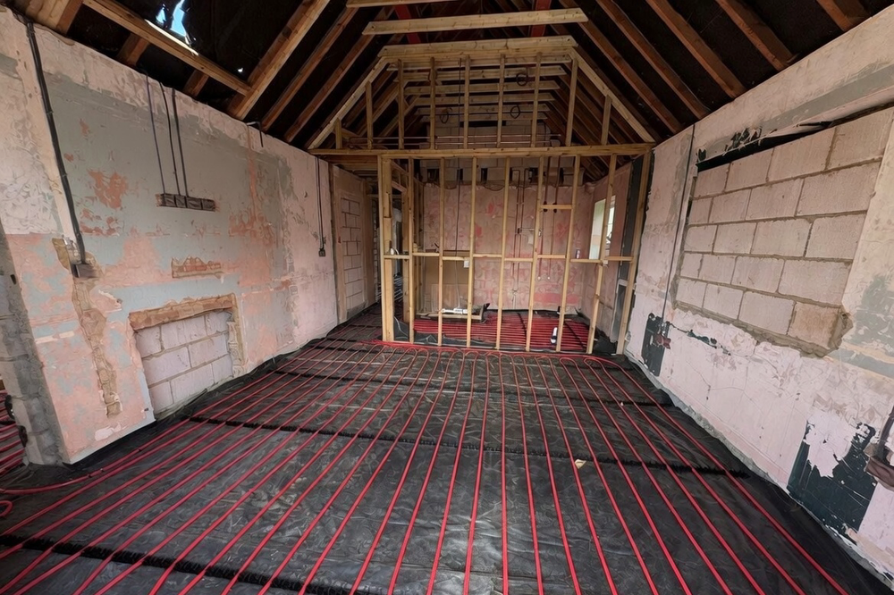 Underfloor heating screed system installation with pipework layout.