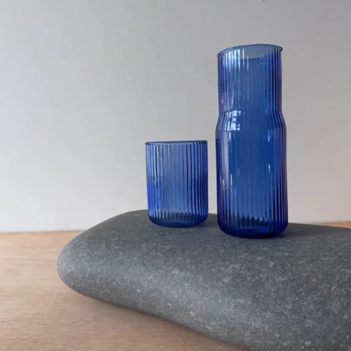 Modern ribbed glass carafe with tinted Pool finish and heat-resistant design.