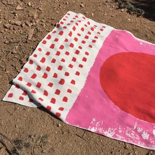 Minimalist pink circle blanket adds playful focus to sofas and beds.