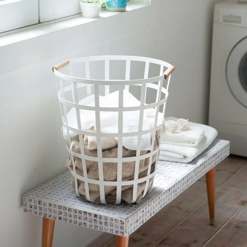 Stylish wire basket for blankets, toys, or laundry with modern steel and wood construction.