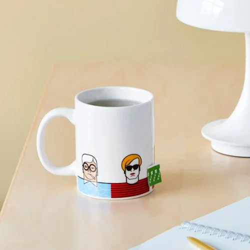 Contemporary workspace featuring Andy Tuohy’s artist mug beside sketchbooks and coffee.