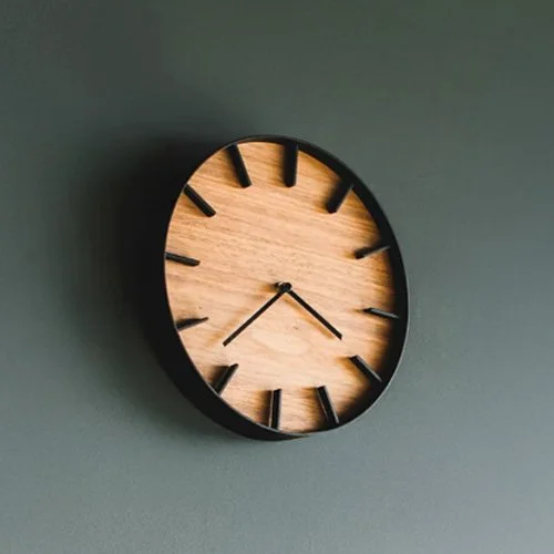Stylish designer wall clock blending precision function with natural wood beauty.