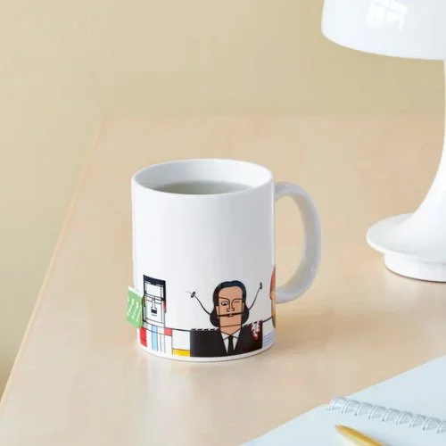 Contemporary workspace featuring Andy Tuohy’s artist mug beside sketchbooks and coffee.