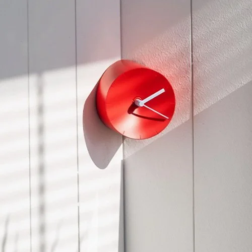 Red Mosery clock by Park Sung-ho and Lee Seong-yong with contrasting white hands.