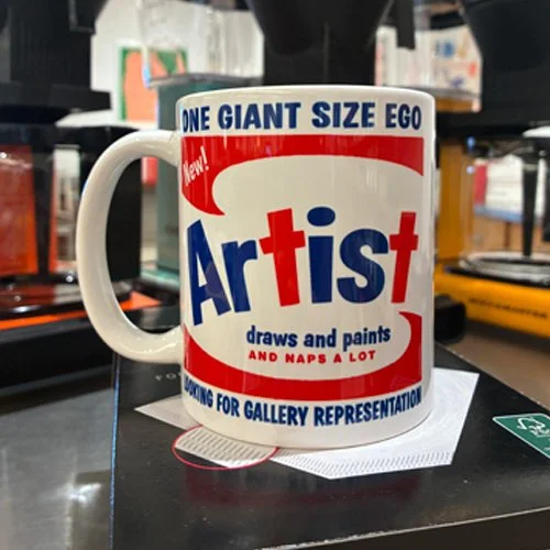 Close-up of the mug’s crisp typography and glossy ceramic finish styled on a minimalist desk.