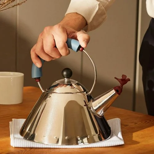 Alessi 9093 stovetop kettle in polished stainless steel with ergonomic handle.