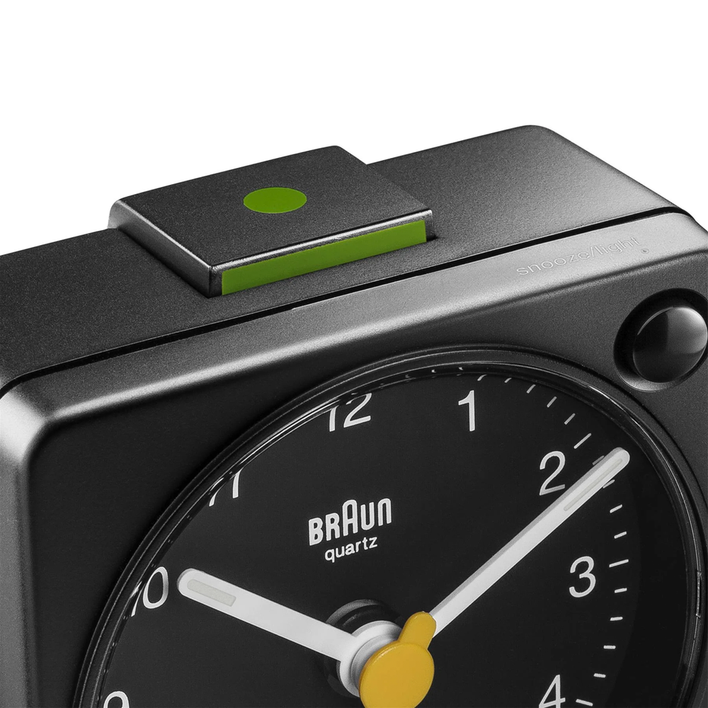 Braun BC02X black travel alarm clock with clean dial and yellow second hand—compact, minimalist, and legible.
