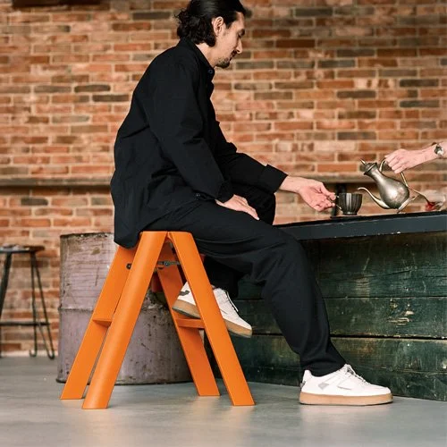 Designer folding stool combining function and bold color for contemporary interiors.