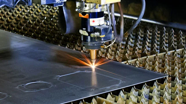 The Mitsubishi laser cutting steel plate on the SAFE-T-FAB shop floor.