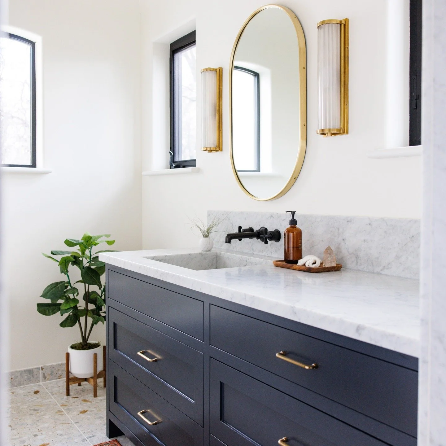 The perfect serene bathroom shows how you can mix metals. The black windows tie in with the black plumbing fixtures and are softened and balanced by the brushed gold finishes. 

Photo by @lindsey_king_photography