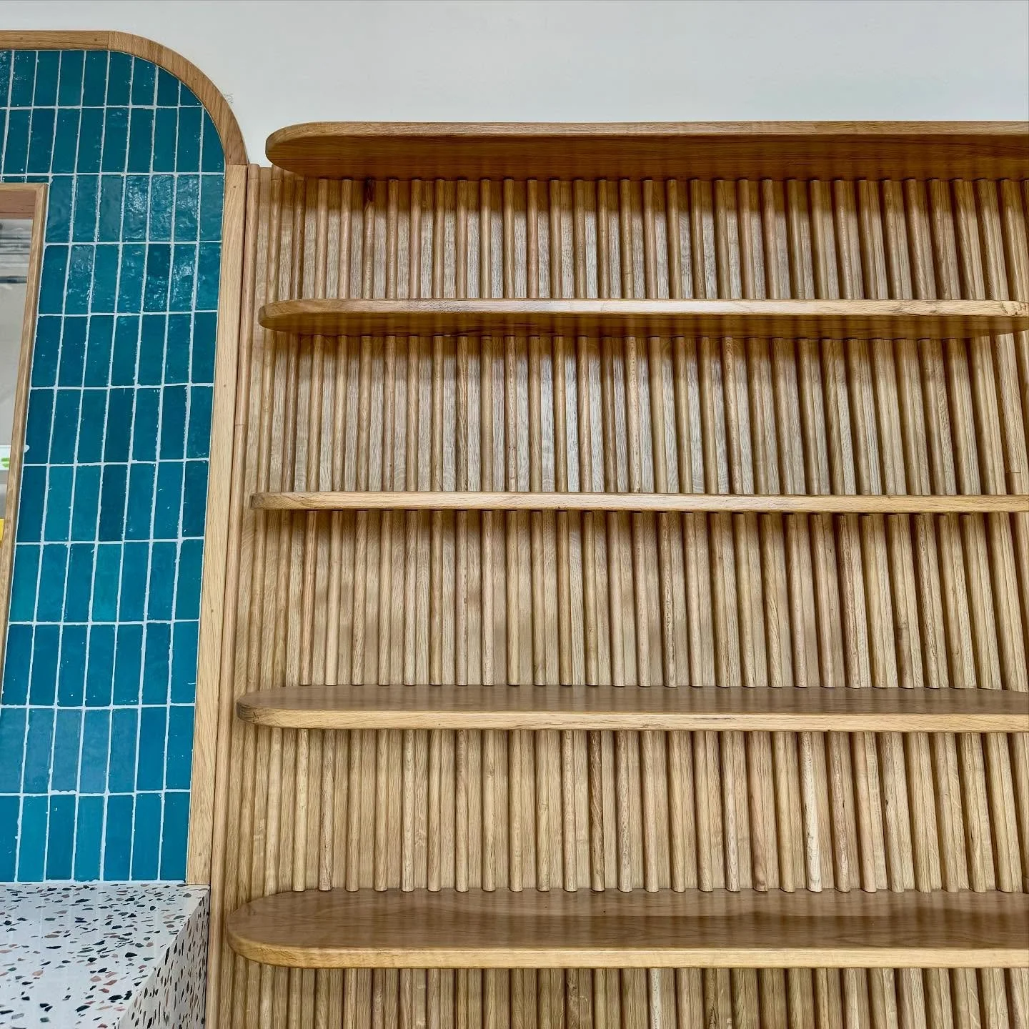 These details are everything. The radius on that backsplash, finished with an oak trim that matches these, soon to be, merchandising shelves.  Coming Soon! 🥖 + 🥐 = 🤤