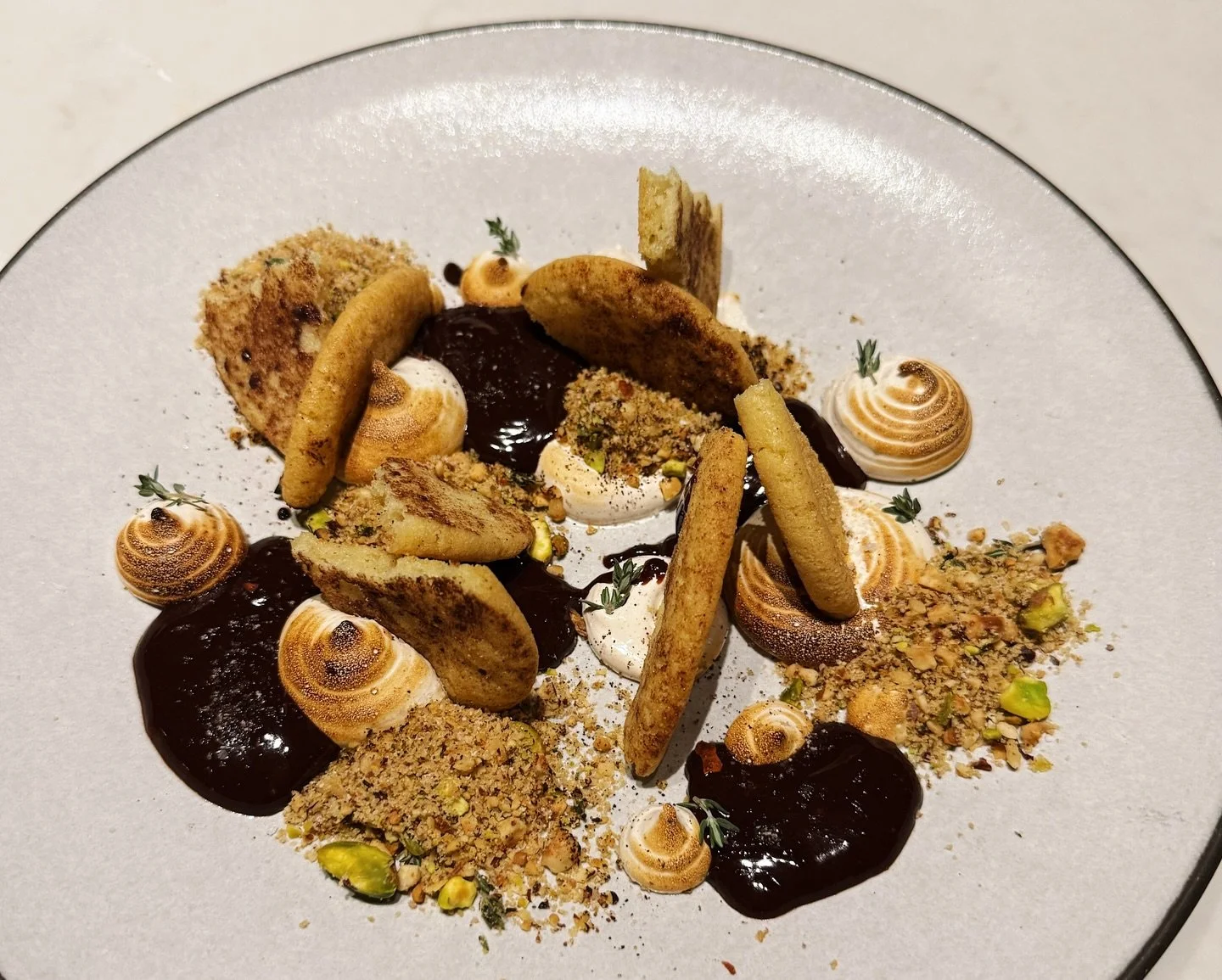 Our newest dessert for the weekend is our take on the campfire classic, S'mores. Brown butter thyme graham cracker, dark chocolate, and a triple toasted Italian meringue. Finished with pistachio and hazelnut for a little extra magic. 🍫✨