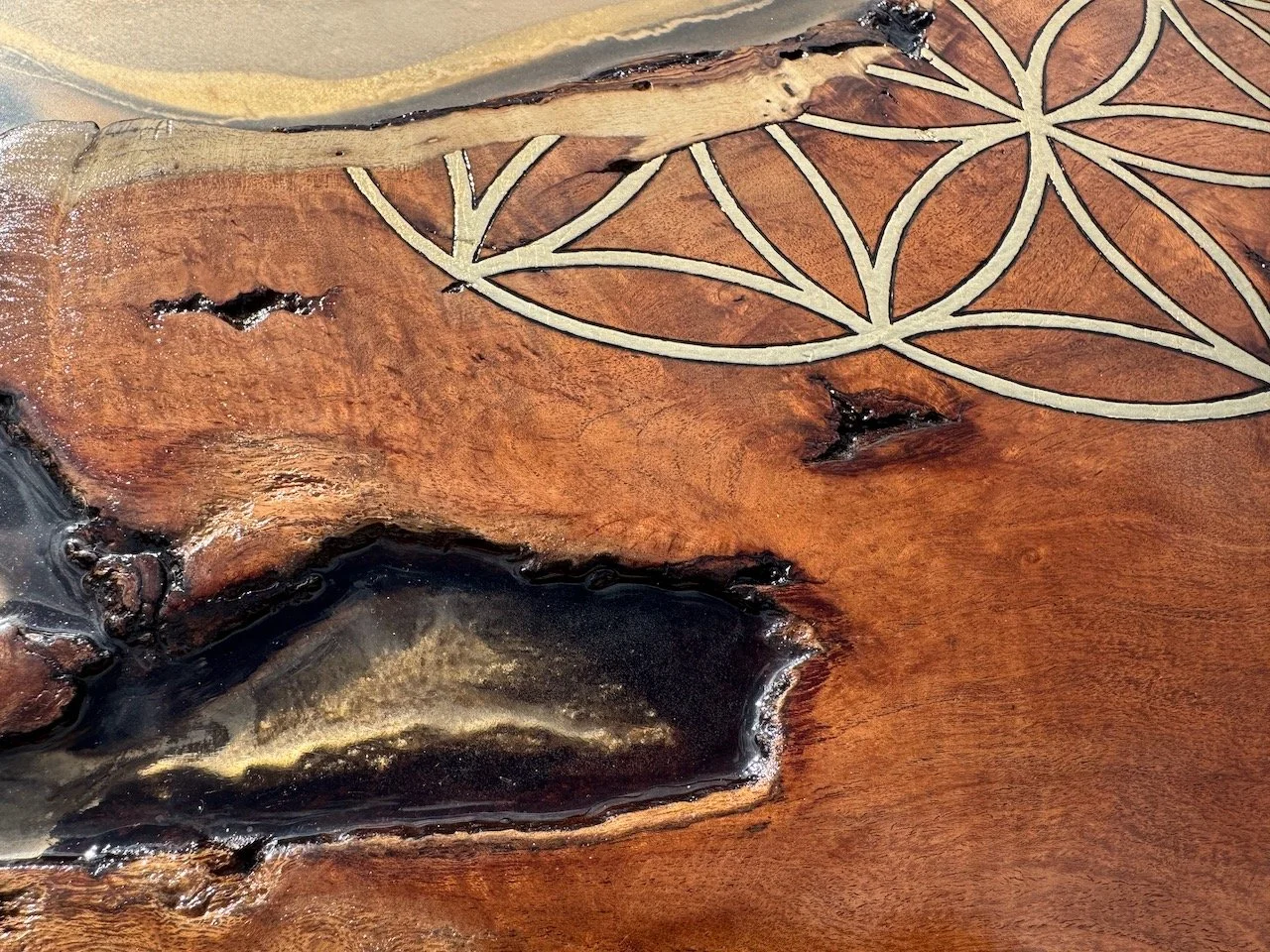 A radiant resin and wood composition by Anne Shackelford featuring gold leaf highlights and a polished, reflective surface.