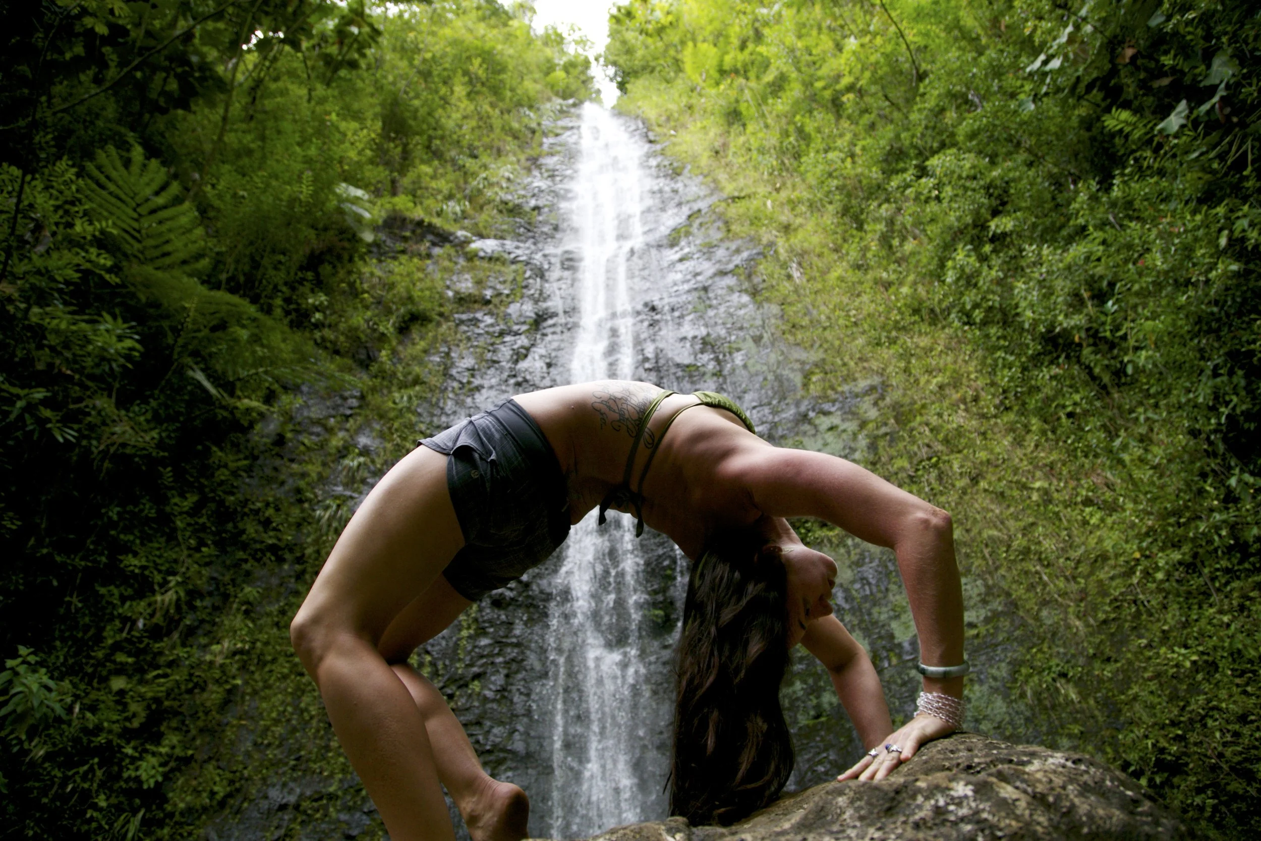  Anne Shackelford in a backbend pose atop a rock at the base of a Hawaiian waterfall, an expression of balance, strength, and harmony with the living world. 2014. 