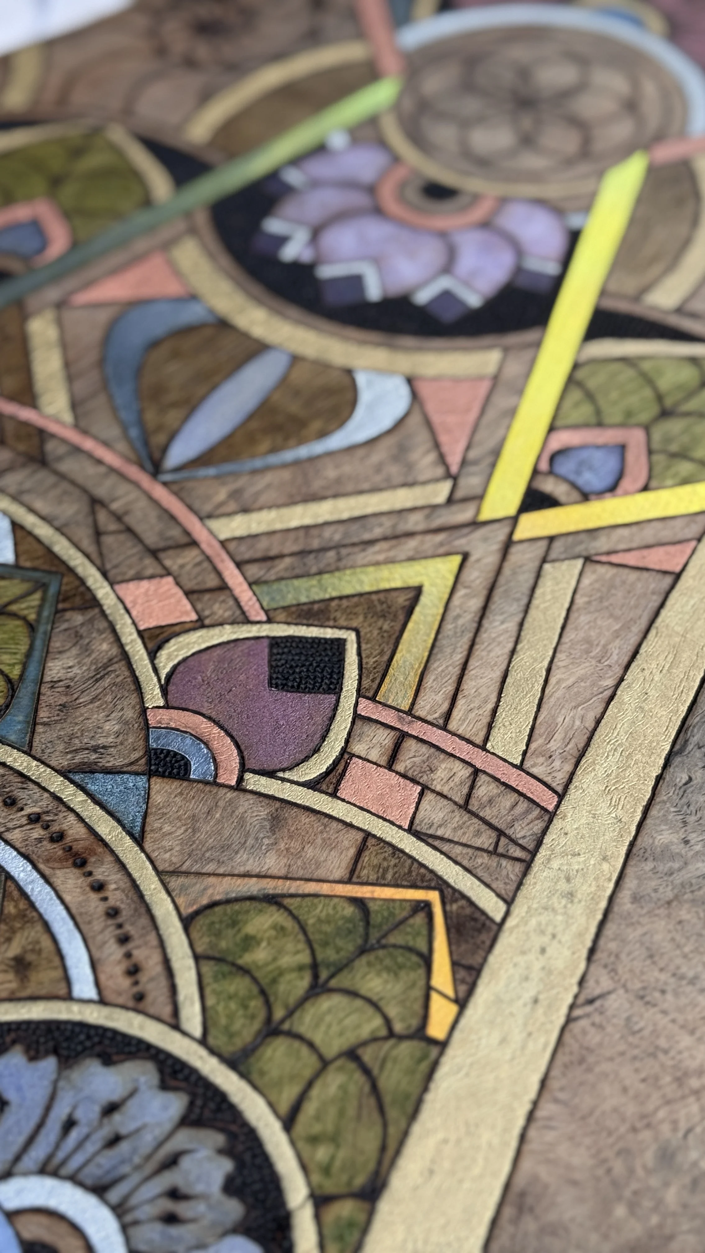 Detail of Alchemy of Becoming featuring pyrography, reflective materials, and intricate pattern work.