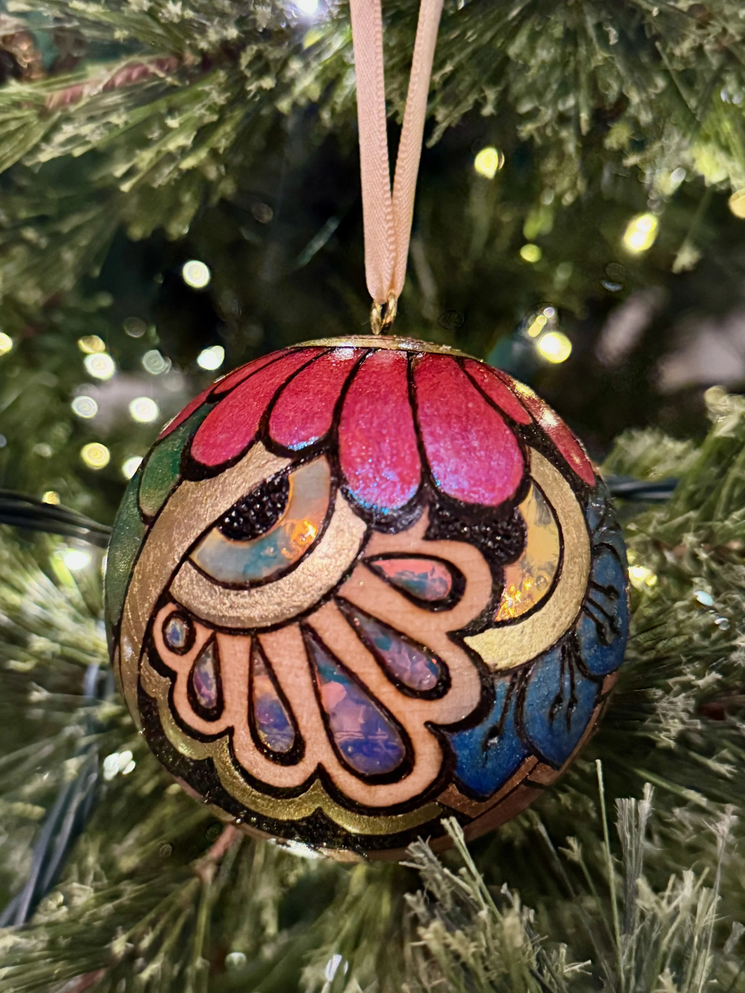 Firelight wood ornament crafted with pigment, gilding, and luminous texture by a Texas artist.