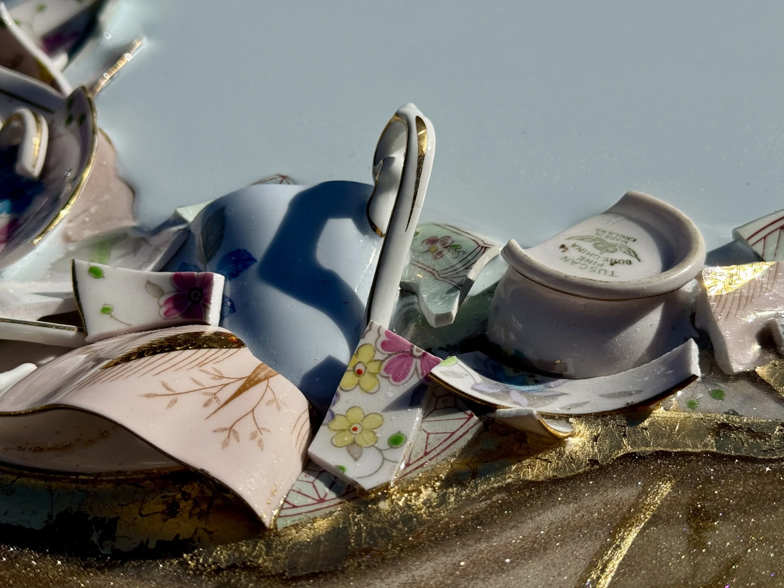 Wall art created from family teacups and saucers with gold leaf inlay